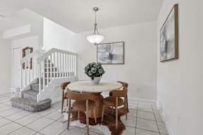 A dining room with a table and chairs.