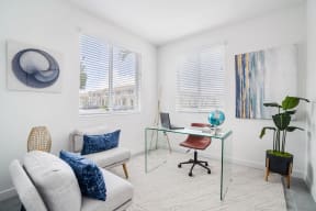 a home office with white walls and a glass desk