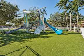A playground with a blue slide and a white structure.