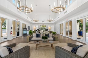 a living room with couches and chairs and chandeliers