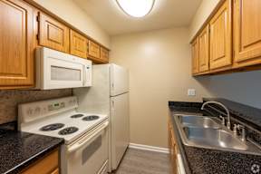 A kitchen with a stove, microwave, and refrigerator.