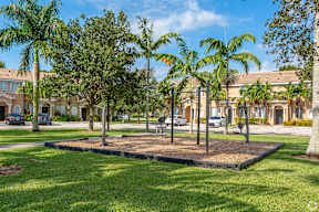 a park with palm trees in front of a building
