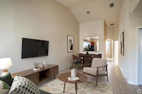 A living room with a flat screen TV mounted on the wall.