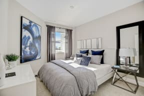 Cozy bedroom featuring a comfortable bed and a large mirror.
