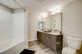 Modern bathroom featuring a large mirror and a sleek toilet.