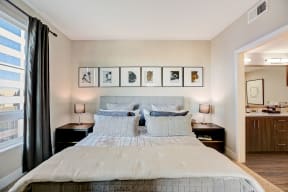 Bedroom with bed and framed pictures at Eleven 10 in Orange, CA