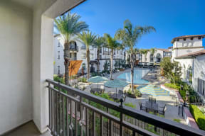 a balcony with a great view of a swimming pool and resort buildings