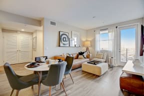 Spacious living room featuring a comfortable couch, dining table with chairs, and modern decor.