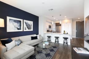 Open living room with a comfortable couch, coffee table, and a view into the modern kitchen.