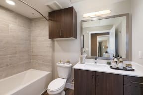 Bathroom with sink, toilet, and mirror at Eleven 10 in Orange, CA