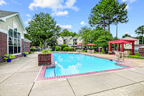 A pool surrounded by a red fence and a red gazebo.