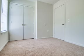 a bedroom with two doors and a carpeted floor
