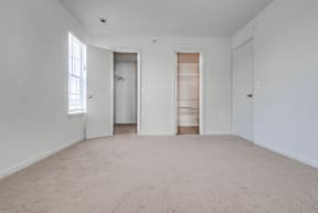 a bedroom with white walls and carpet
