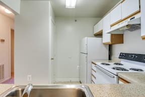 a kitchen with white appliances and white cabinets