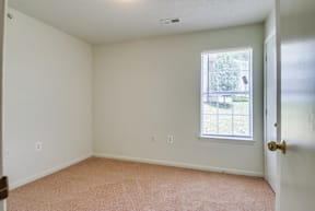 a bedroom with white walls and carpet