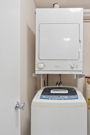 A white dryer and washer are mounted on a wall.