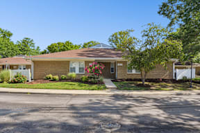 A house with a brown roof and a white fence.