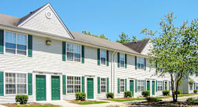 a white building with green doors and shutters