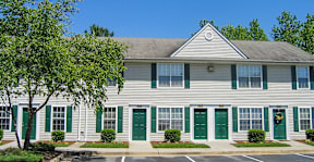 a white house with green doors and shutters