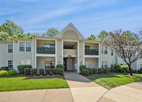 A large apartment complex with a green lawn in front.