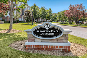 Community Entrance Sign on Grass in Front of Tree Line