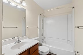 A white bathroom with a sink, toilet, and bathtub.