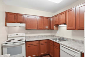 A kitchen with brown cabinets and a white stove.
