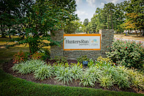 A sign for Hunters Run Apartments