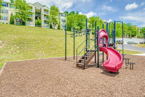 Playground For Children on wood chips and Apartment buildings in the background
