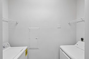 A white laundry room with a washer and dryer.