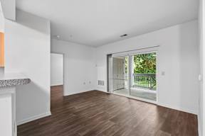 A room with a sliding glass door leading to a balcony.