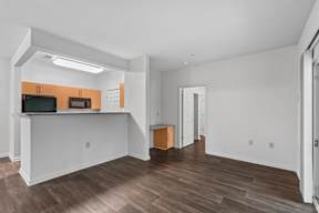 a living room with a view of the kitchen