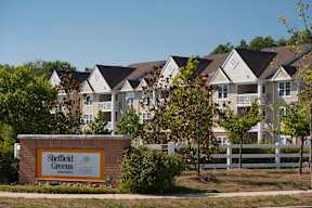 apartments with a community sign in front of them
