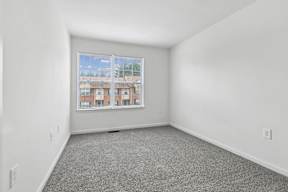 A room with a large window and a view of a building outside.