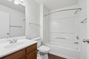 A white bathroom with a toilet, sink, and bathtub.