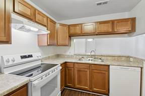 A kitchen with white appliances and wooden cabinets.