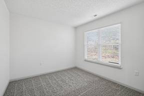 A room with a window covered in blinds.