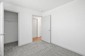A white room with a carpeted floor and two doors.