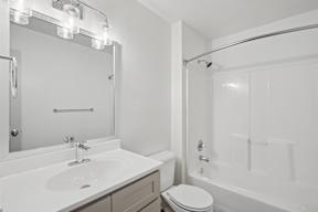 A white bathroom with a toilet, sink, and bathtub.