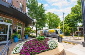 a train traveling down a street next to a building