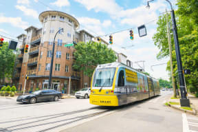 a yellow streetcar on a city street in front of a building