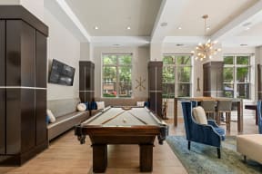 a living room with a pool table and a dining room