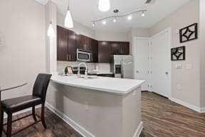 a white kitchen with a large island and black chairs