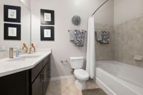 a bathroom with a toilet and a tub and a sink