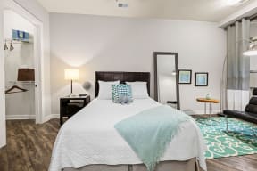 a bedroom with a bed and a mirror on the wall