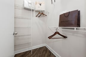 a closet with shelves and a bag hanging on a rack