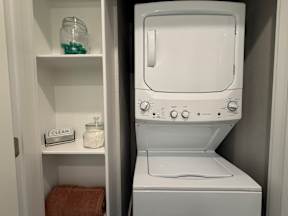 A white washing machine is in a small laundry room.