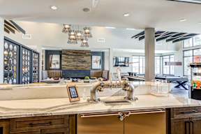 A modern kitchen with a large island and a wooden backsplash.