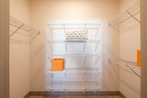 Empty shelves in a white pantry.