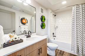 A bathroom with a white toilet, a sink, and a shower with a striped shower curtain.
